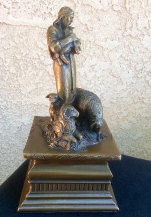 Bronze sculpture by Annette Everette of Jesus holding a tiny lamb, with sheep at His feet.