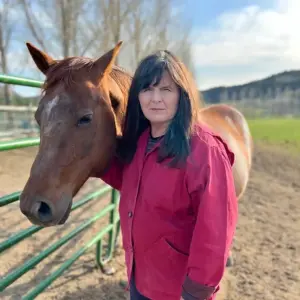 picture of Julie Rogers standing next to a horse