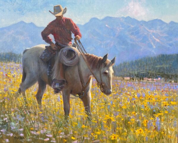 cowboy on a horse walking through a field of wildflowers