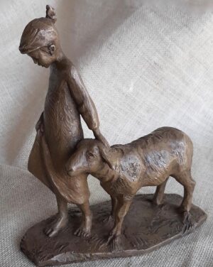 bronze sculpture of a young girl leading home a single sheep