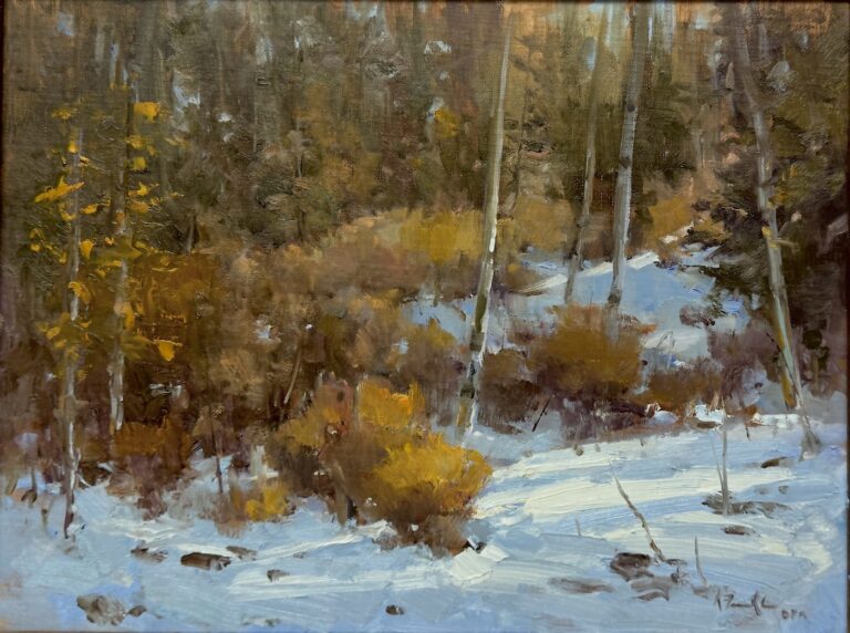 woods scene with snow covered ground and orange bushes