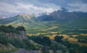 A realist landscape painting titled 'San Juan Mountains' by Richard Boyer. The perspective looks out from an elevated, rocky foreground filled with green shrubs down into a vast valley floor with golden and green fields. In the background, a massive, rugged mountain range rises dramatically beneath a sweeping, overcast sky with textured gray and white clouds.