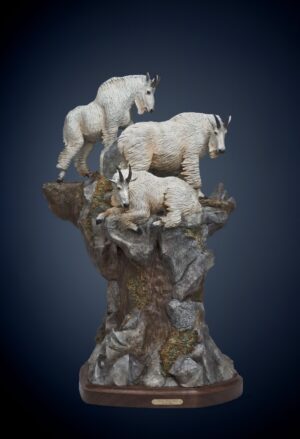 sculpture by fred boyer of 3 mountain sheep perched on a cliff