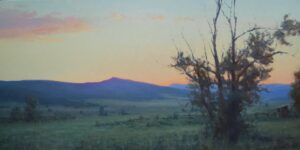 landscape painting by Kyle Stuckey of a tree in the forground and a colorful mountain range in the background